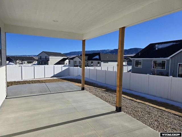 view of patio with a mountain view, a fenced backyard, and a residential view