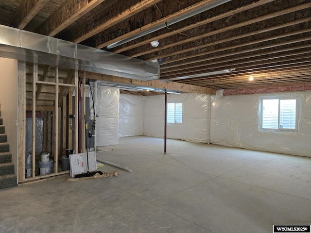 basement with a healthy amount of sunlight and stairs