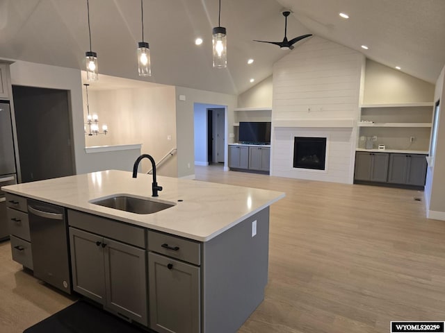 kitchen featuring gray cabinets, a kitchen island with sink, a sink, and dishwasher