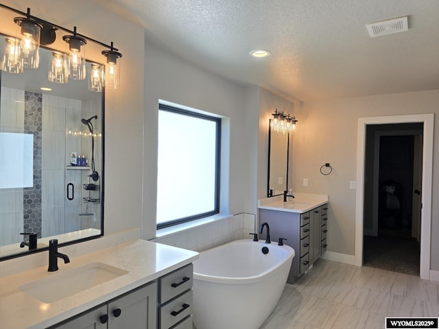 full bathroom featuring a stall shower, a freestanding bath, visible vents, and a sink