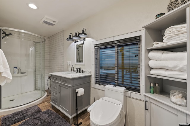 bathroom featuring hardwood / wood-style flooring, vanity, an enclosed shower, and toilet