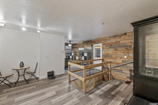 interior space with wood-type flooring, wood walls, and a textured ceiling