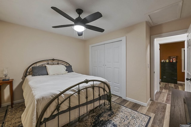 bedroom featuring ceiling fan, wood-type flooring, and a closet