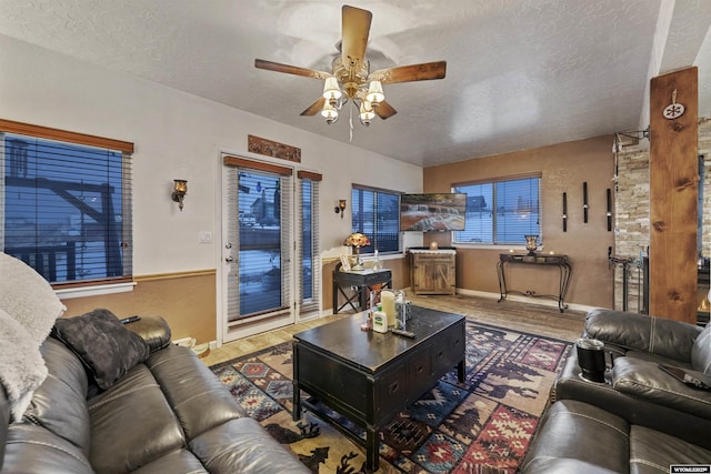 living room with hardwood / wood-style flooring, ceiling fan, and a textured ceiling