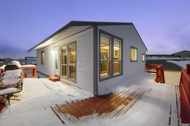 snow covered property with a wooden deck