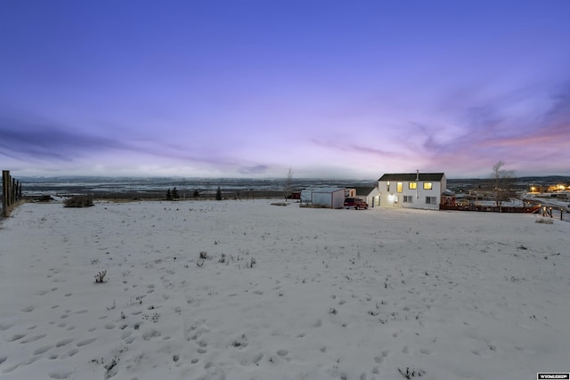 snowy yard with a storage shed