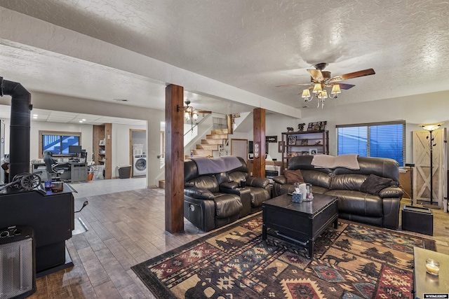 living room featuring ceiling fan, dark wood-type flooring, a textured ceiling, and washer / dryer