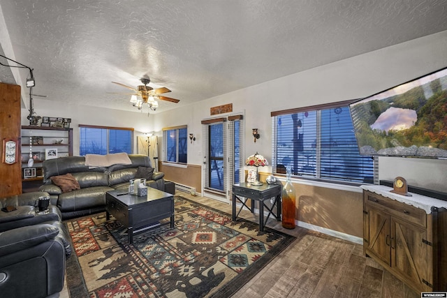 living room with a textured ceiling, hardwood / wood-style floors, ceiling fan, and a baseboard heating unit