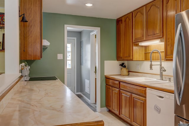 kitchen featuring exhaust hood, white dishwasher, stainless steel fridge, and sink