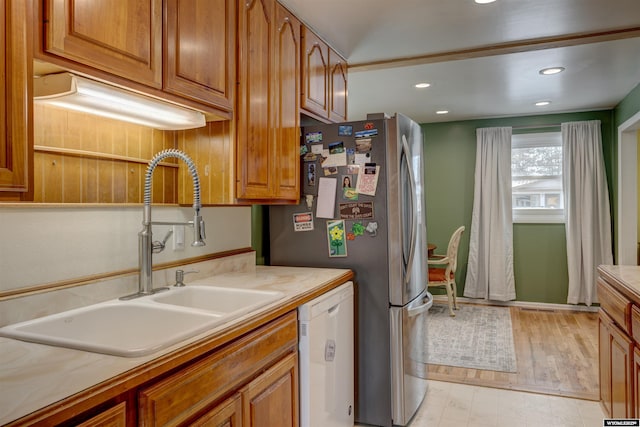 kitchen featuring sink, dishwasher, and stainless steel fridge