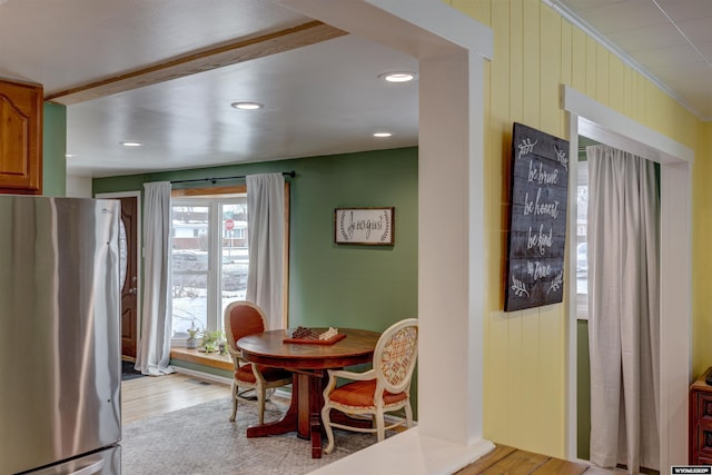 dining room with crown molding and light hardwood / wood-style floors