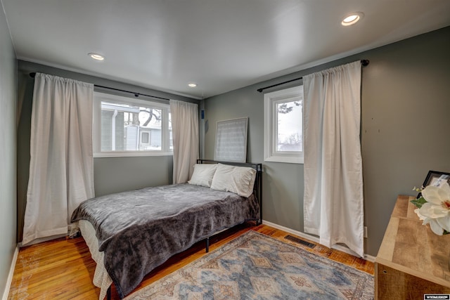 bedroom featuring light hardwood / wood-style flooring and multiple windows