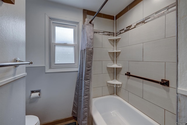 bathroom featuring shower / bath combination with curtain and toilet