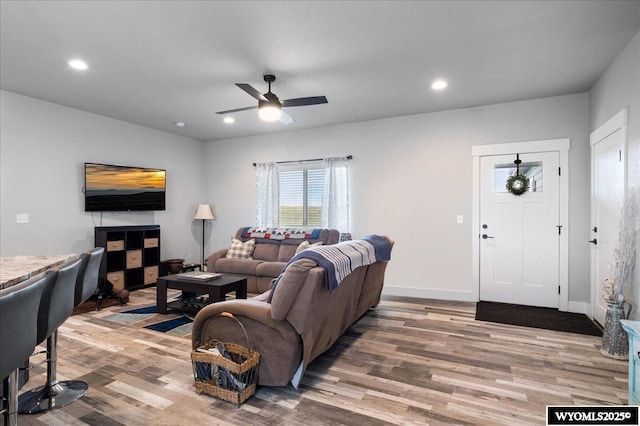 living room featuring baseboards, ceiling fan, wood finished floors, and recessed lighting