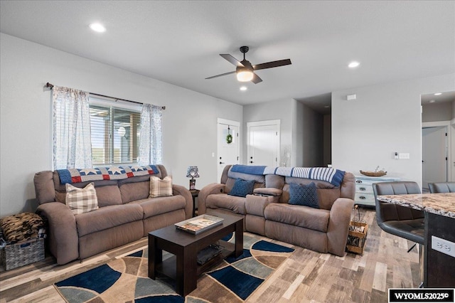 living room featuring light wood-style floors, a ceiling fan, and recessed lighting