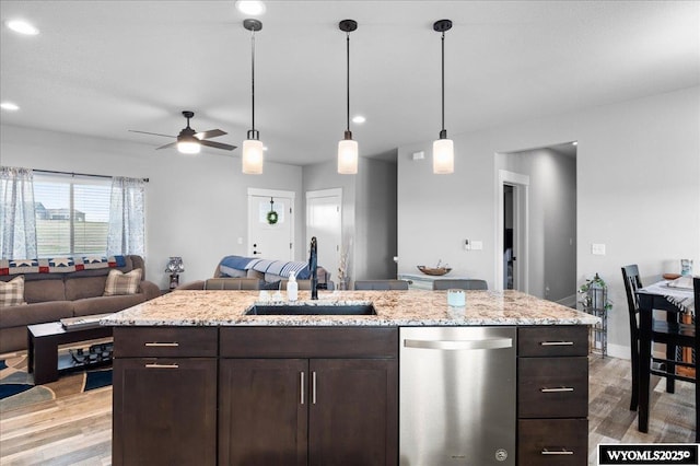 kitchen featuring dishwasher, light wood-style floors, open floor plan, and a sink