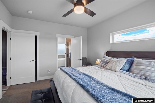 carpeted bedroom featuring a ceiling fan, ensuite bath, and baseboards