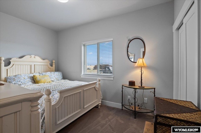 bedroom with baseboards and dark carpet