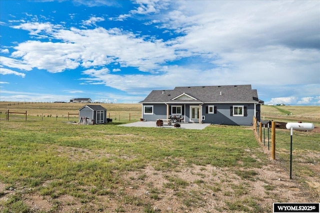 back of house featuring a patio, a storage unit, fence, a rural view, and an outdoor structure