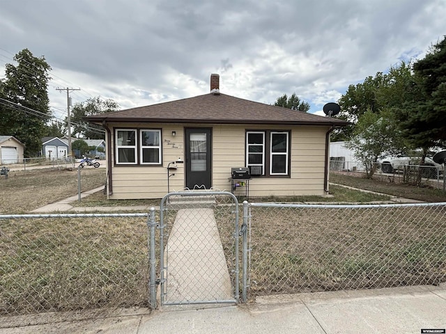 bungalow-style house featuring roof with shingles, a fenced front yard, a chimney, and a gate