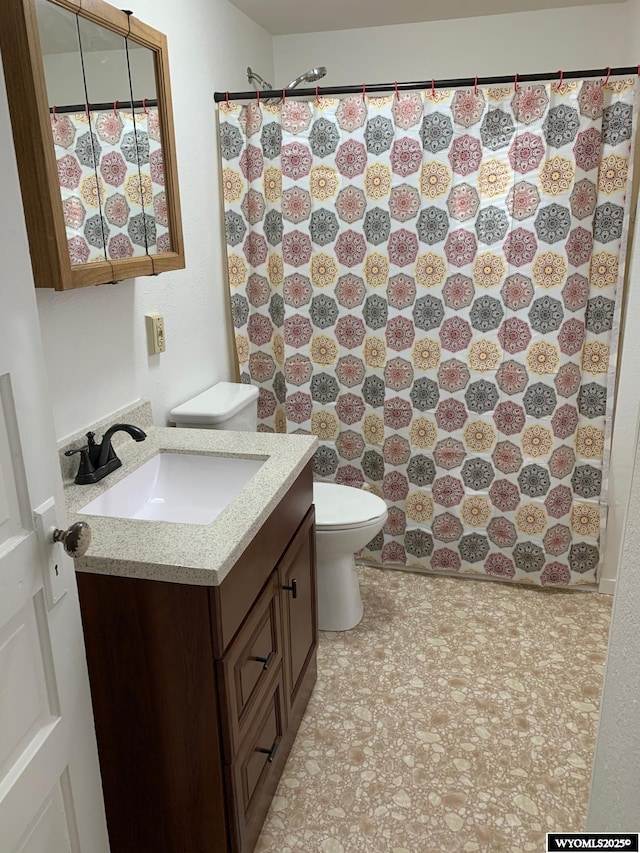 bathroom with toilet, a shower with shower curtain, and vanity