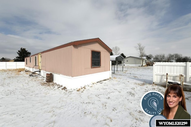 view of snowy exterior featuring fence