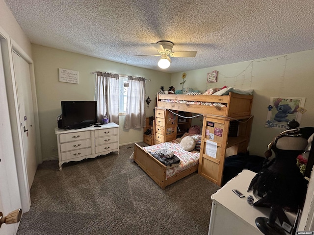 bedroom with ceiling fan, dark carpet, and a textured ceiling