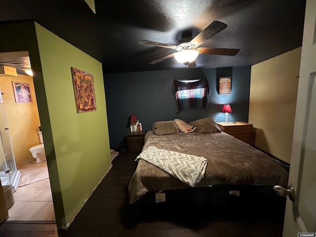 tiled bedroom featuring connected bathroom and a ceiling fan