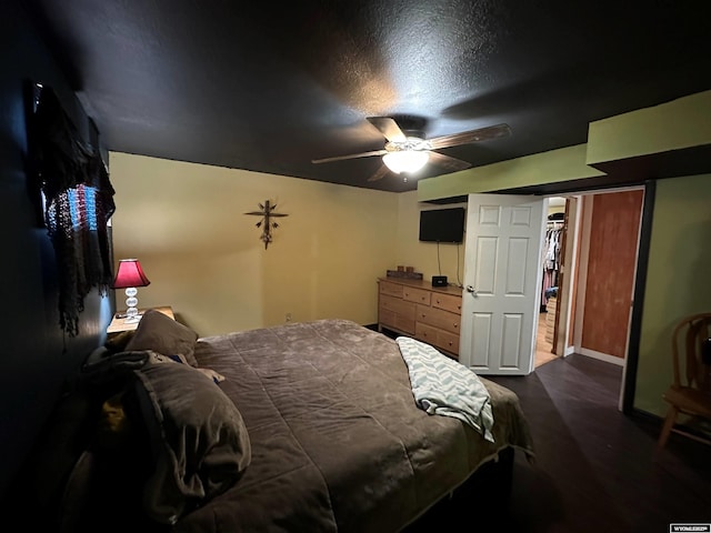 bedroom with a ceiling fan and dark wood-style flooring