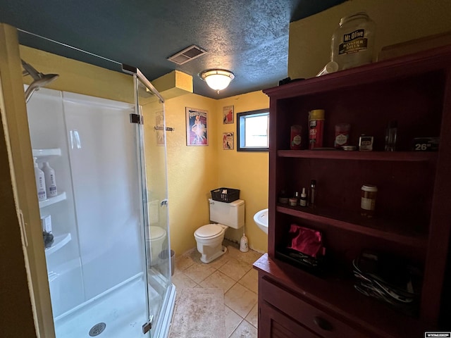 bathroom featuring a textured ceiling, toilet, a shower stall, and visible vents