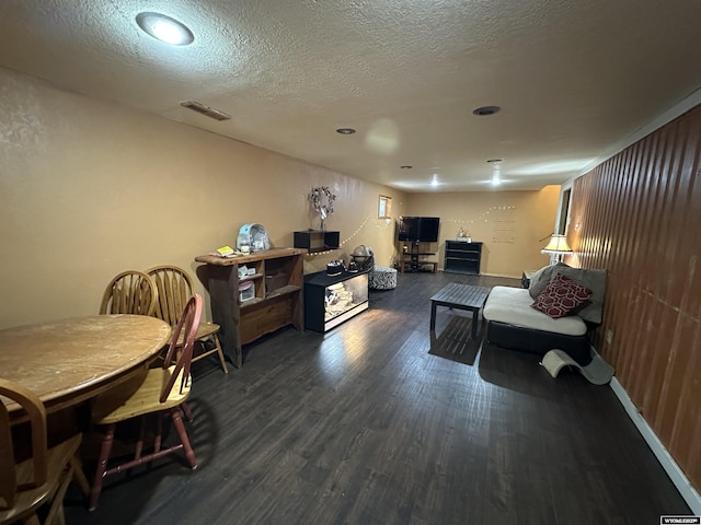 living room with visible vents, dark wood finished floors, and a textured ceiling