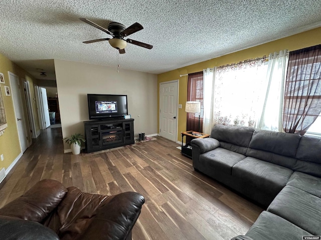 living room featuring a textured ceiling, wood finished floors, a wealth of natural light, and baseboards