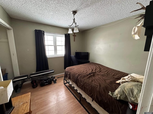 bedroom featuring a textured ceiling and wood finished floors