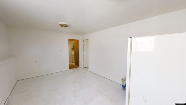 unfurnished room featuring a baseboard radiator and concrete flooring