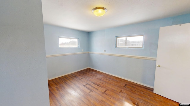 empty room featuring baseboards and wood finished floors