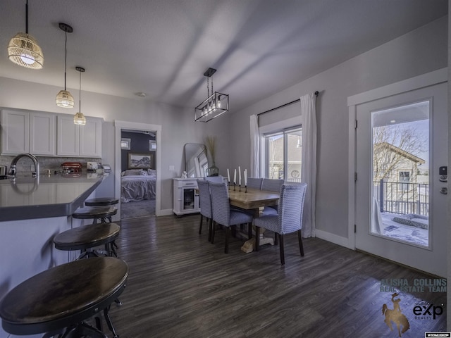 dining area featuring dark wood-type flooring and baseboards