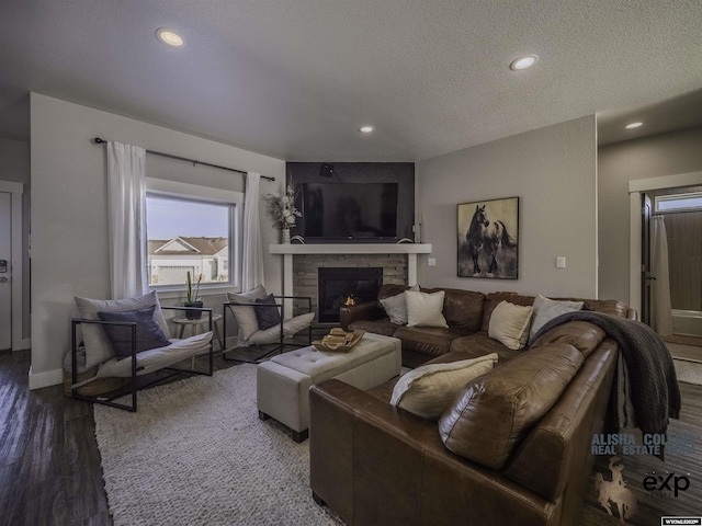 living room featuring a fireplace, wood finished floors, and recessed lighting