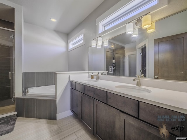 full bathroom with a stall shower, a garden tub, a sink, and double vanity