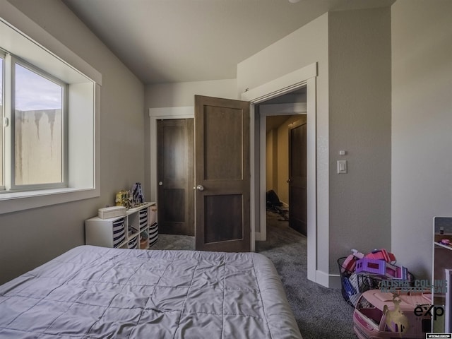 bedroom featuring dark carpet and baseboards