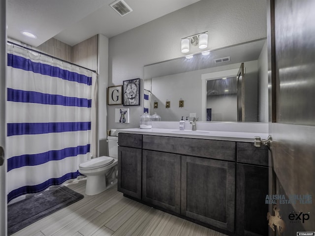 full bathroom featuring visible vents, vanity, toilet, and wood finished floors