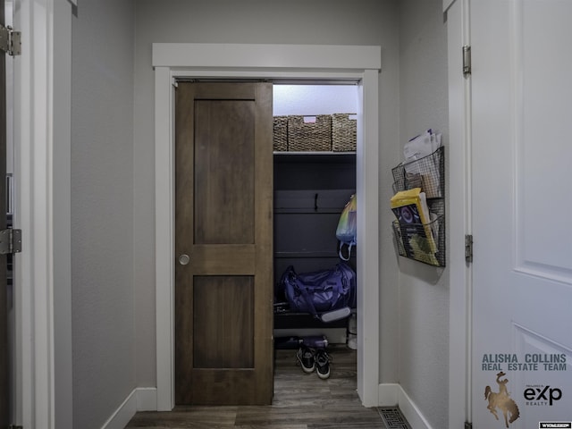 hallway featuring dark wood-style floors and baseboards