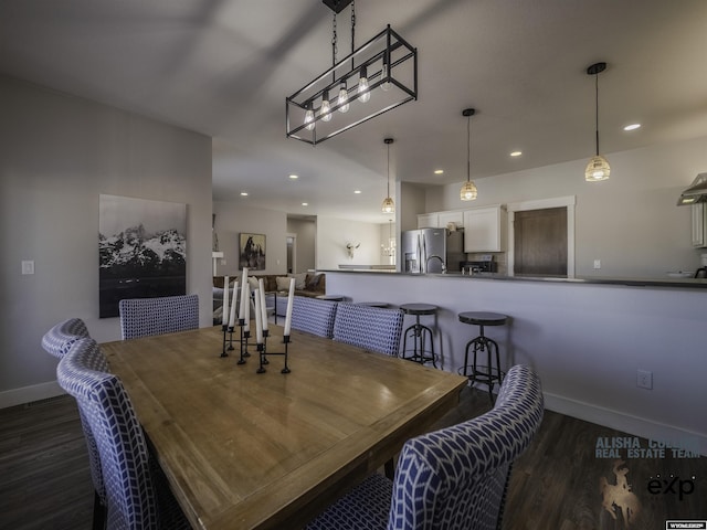 dining space with baseboards, dark wood finished floors, and recessed lighting