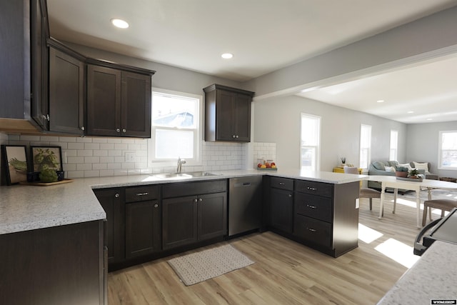 kitchen featuring light wood-style floors, open floor plan, a sink, and stainless steel dishwasher