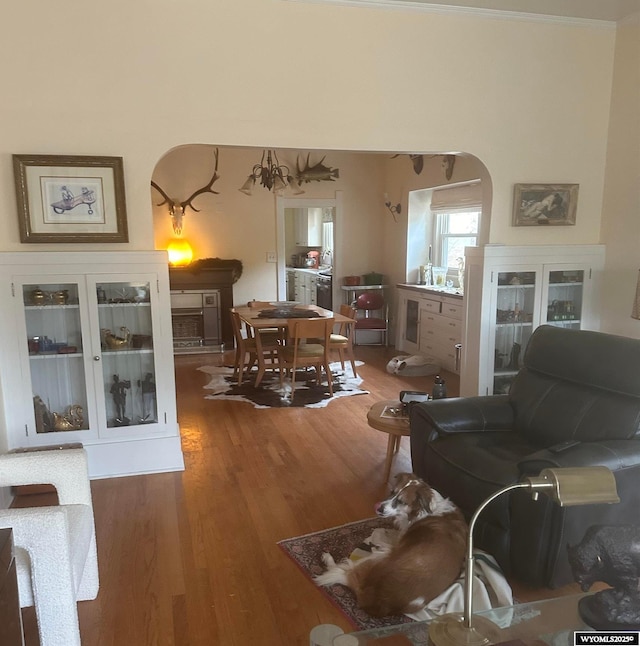 interior space with arched walkways and wood finished floors