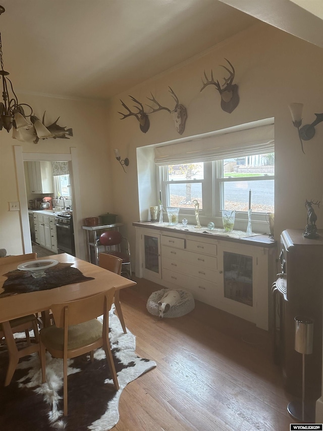 kitchen featuring a notable chandelier, dishwasher, and light wood-style flooring