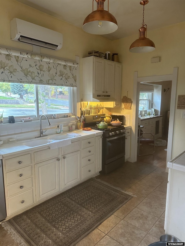 kitchen featuring appliances with stainless steel finishes, white cabinets, light countertops, and a wall mounted AC