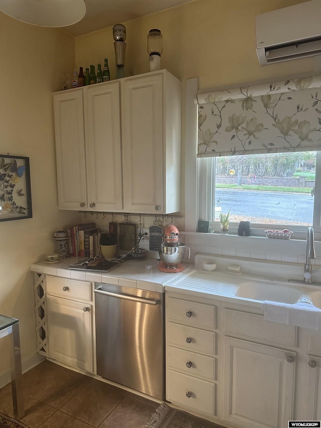 kitchen featuring tile countertops, a sink, white cabinetry, a wall mounted AC, and dishwasher