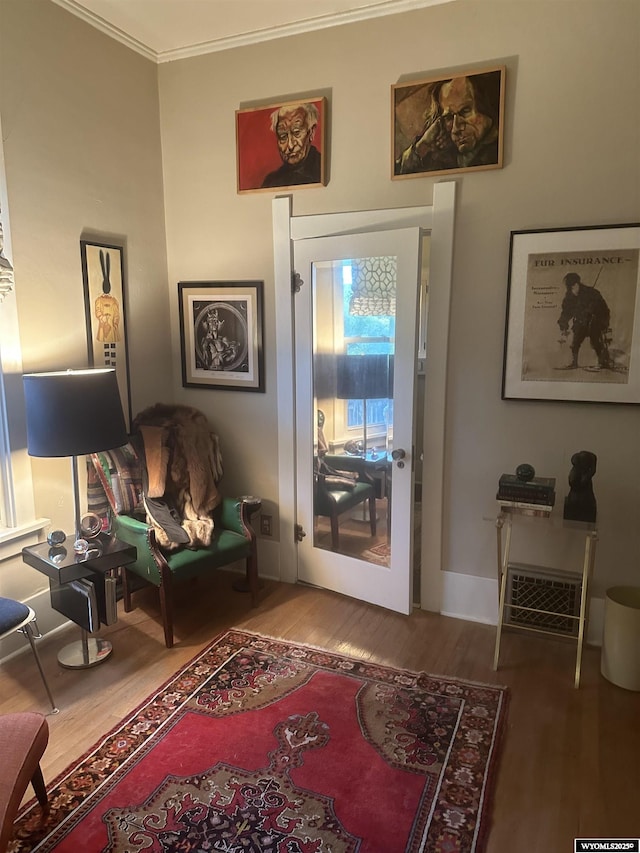 interior space with crown molding, baseboards, and wood finished floors