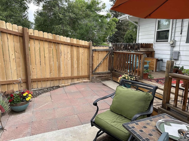 view of patio / terrace featuring a gate, fence, and a deck