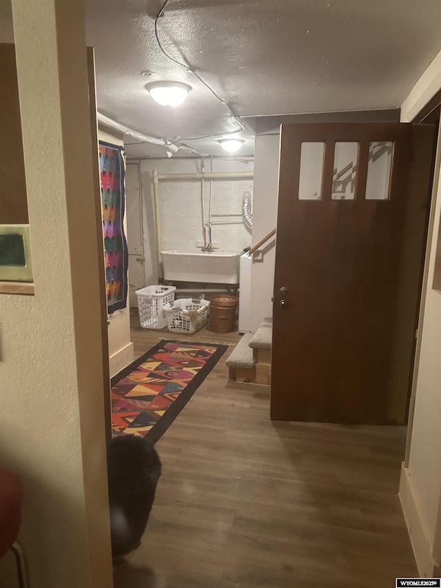 interior space featuring stairs, wood finished floors, a textured ceiling, and a sink